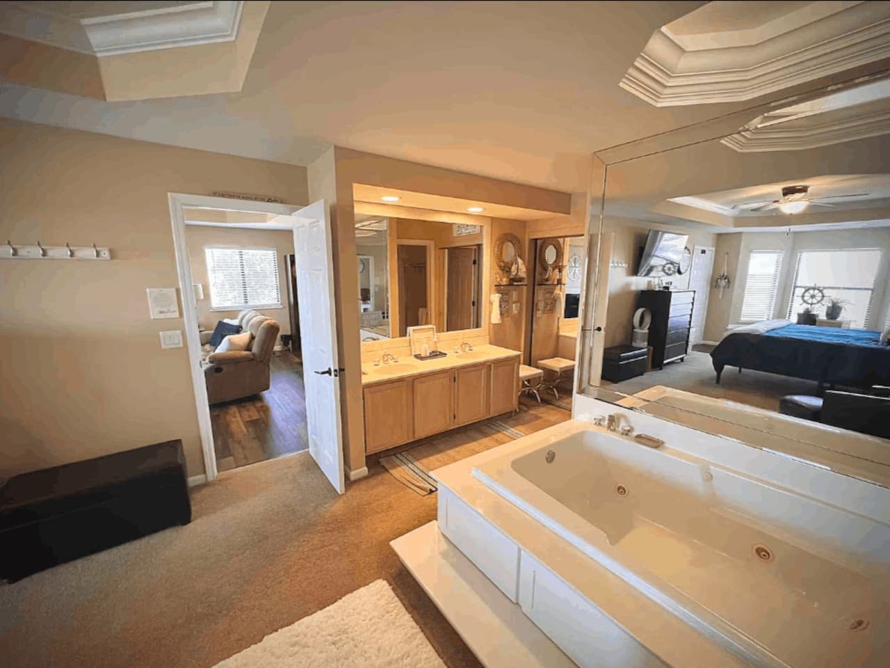 This master suite boasts a luxurious jetted tub, perfect for unwinding after a day of lake adventures, along with a spacious vanity and direct access to the bedroom and living area.