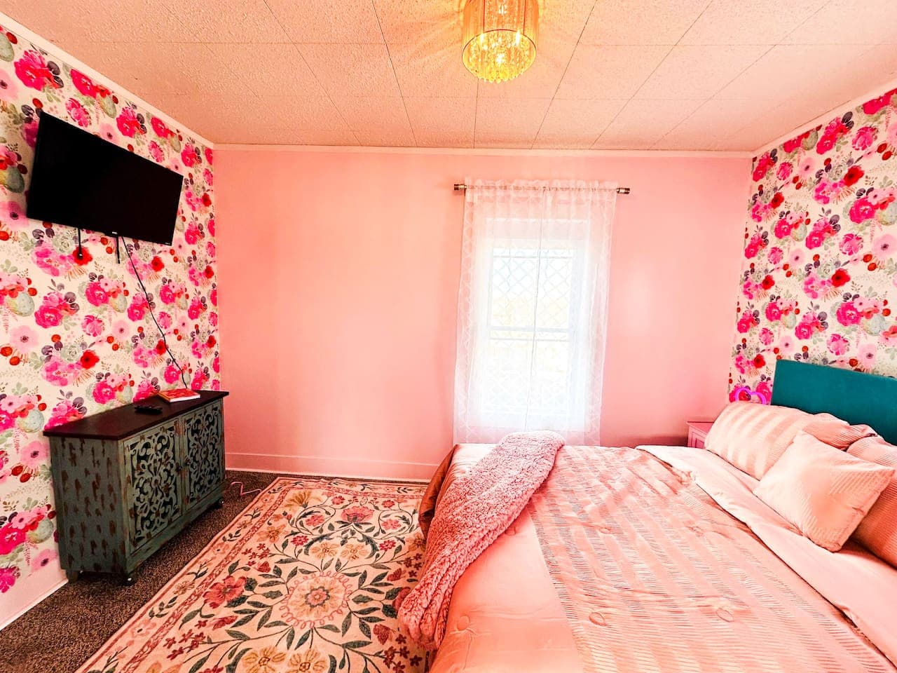 Unwind in this stylish pink-themed Airbnb bedroom with plush bedding, floral accents, and modern comfort—perfect for romantic getaways, girls’ trips, and weekend stays near top attractions.