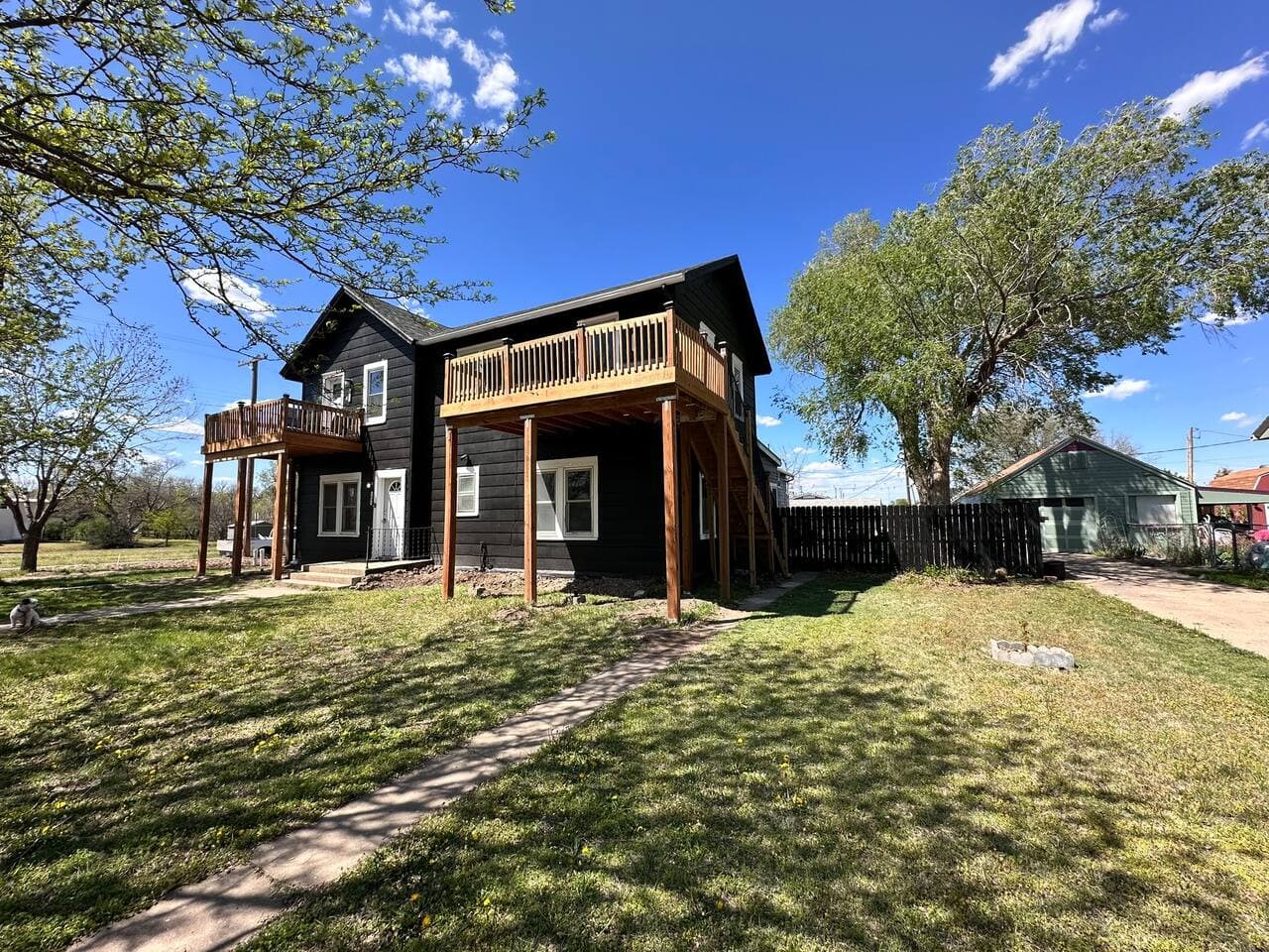 Stay at this stylish black farmhouse Airbnb with private balconies and open green space, perfect for family vacations, group getaways, and relaxing weekends near dining, shopping, and local attractions.