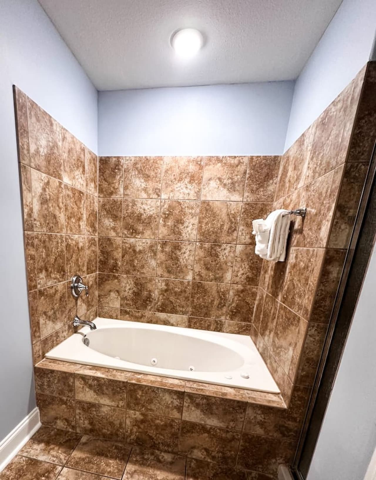 Unwind in the spacious master bathroom featuring a deep soaking jetted tub and walk-in shower, attached to the queen suite for ultimate comfort.