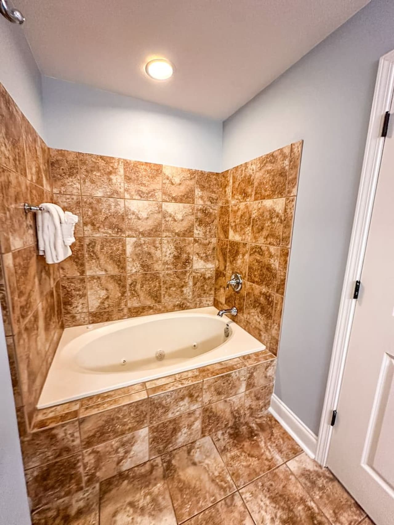 A deep soaking tub with tiled walls for a spa-like feel.
