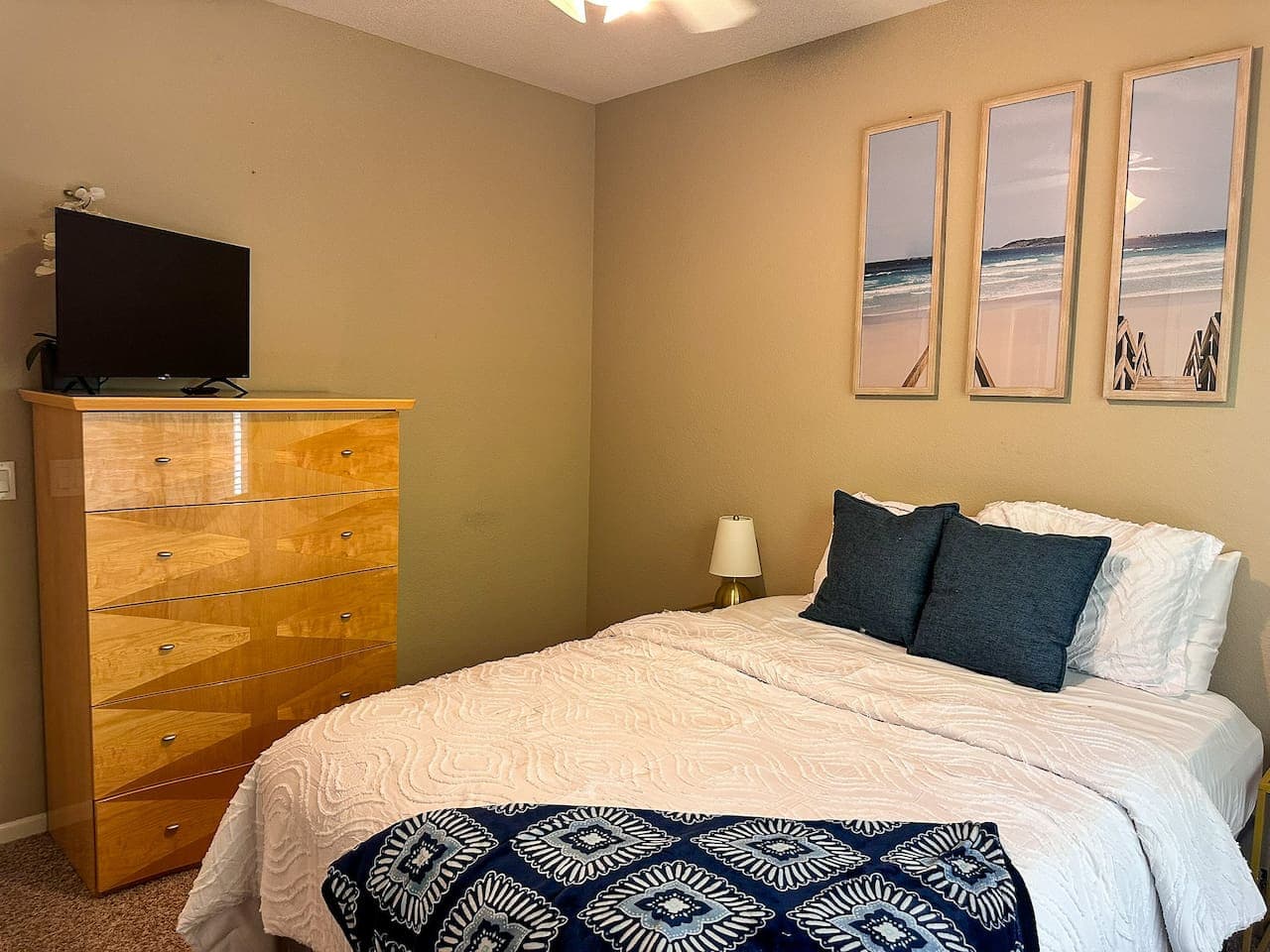 This cozy bedroom provides a comfortable retreat with a queen-sized bed, perfect for unwinding after a day of activities. Enjoy entertainment on the wall-mounted flat-screen TV, while ample storage is available in the stylish dresser for your belongi