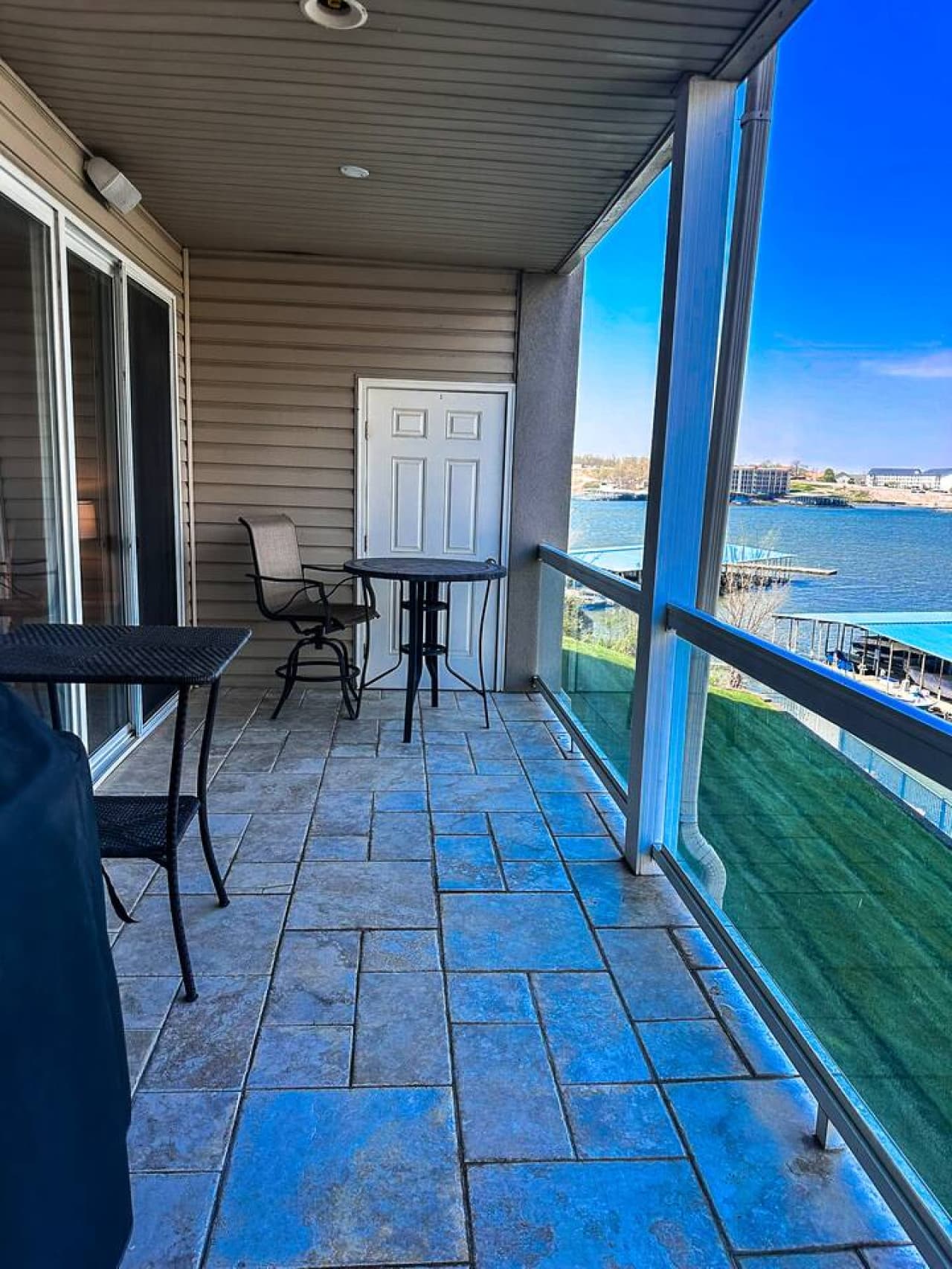 This inviting outdoor patio space offers breathtaking views of the sparkling lake and distant landscape, providing a perfect spot for relaxation. Complete with comfortable outdoor seating, it's an ideal setting for enjoying your morning coffee or eve