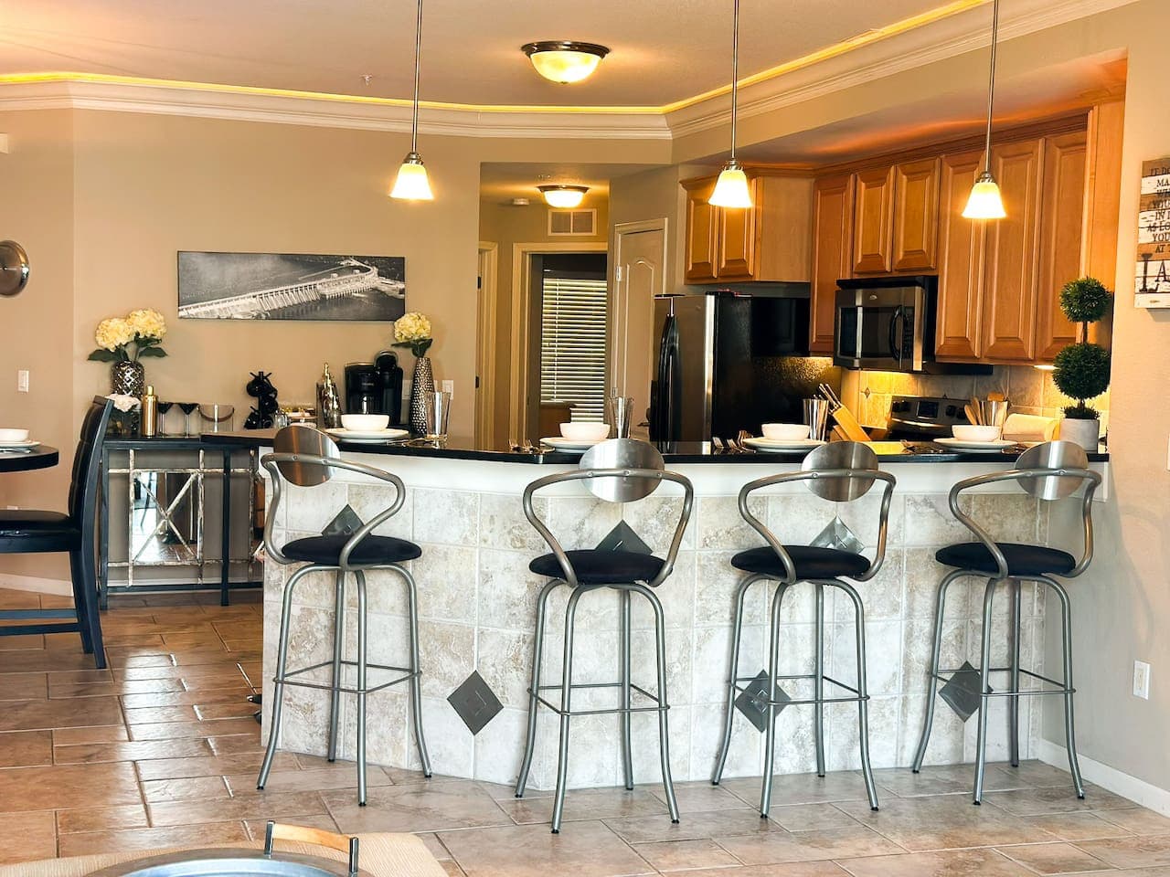 This welcoming living area features a plush sectional sofa, perfect for relaxing and enjoying the large flat-screen TV mounted above a modern fireplace. The space is thoughtfully decorated with inviting accents, creating a cozy and comfortable ambian