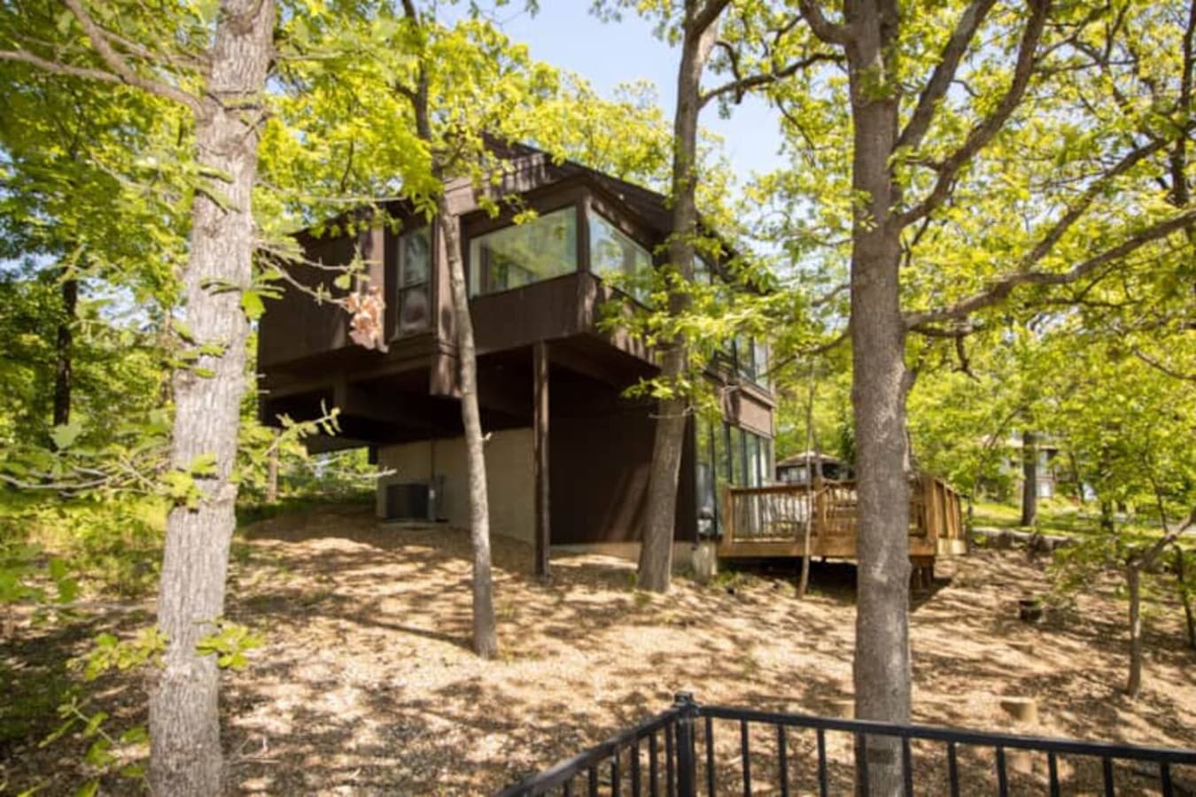 This modern elevated home offers a unique "treetop" living experience, blending seamlessly with the surrounding lush natural landscape. Multiple large windows allow for abundant natural light and scenic views, making this a bright and inviting retrea