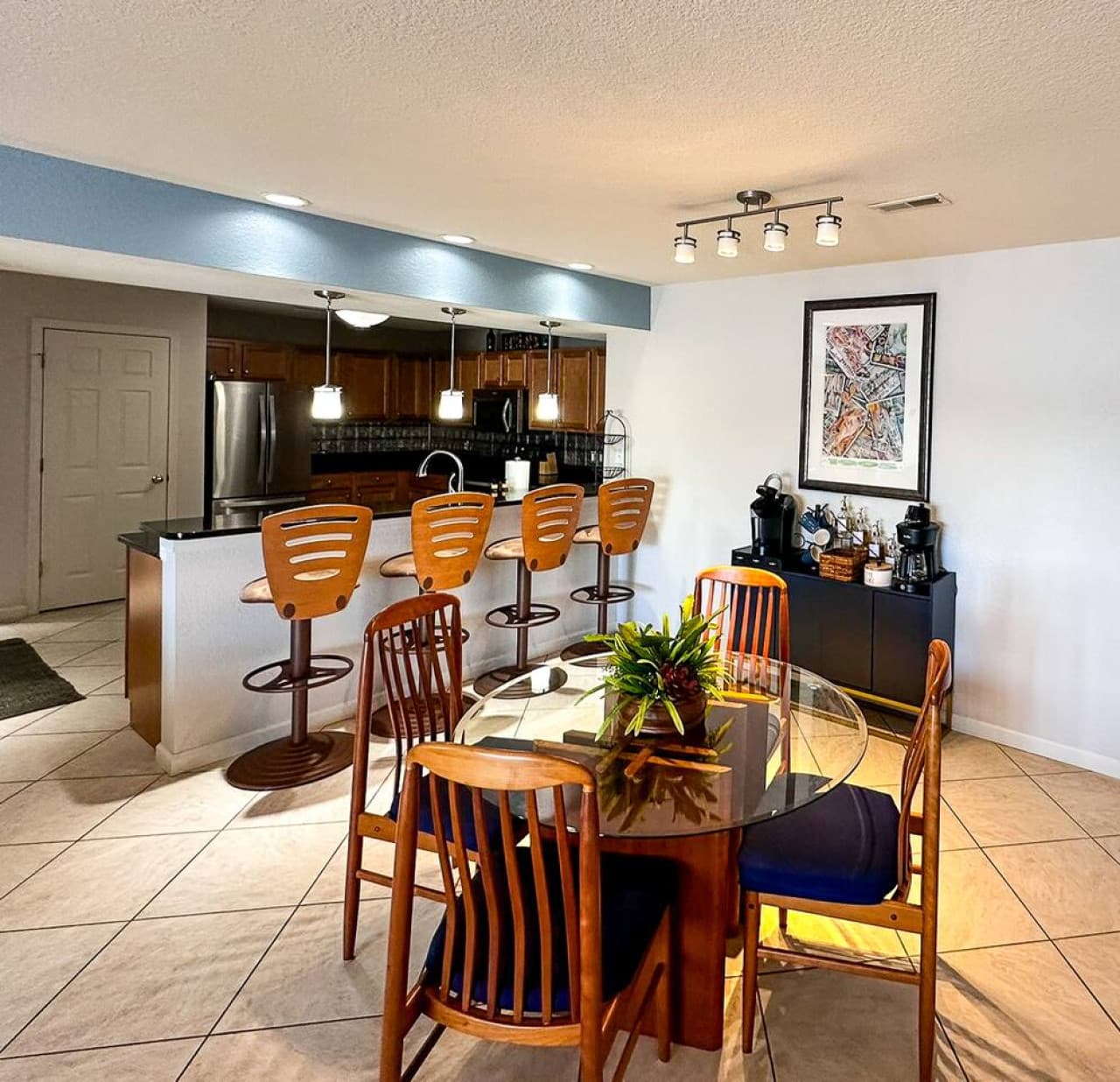 The kitchen and dining areas are bright and spacious, with stylish pendant lighting, a fully equipped kitchen, and a beautifully set dining table for a comfortable stay.