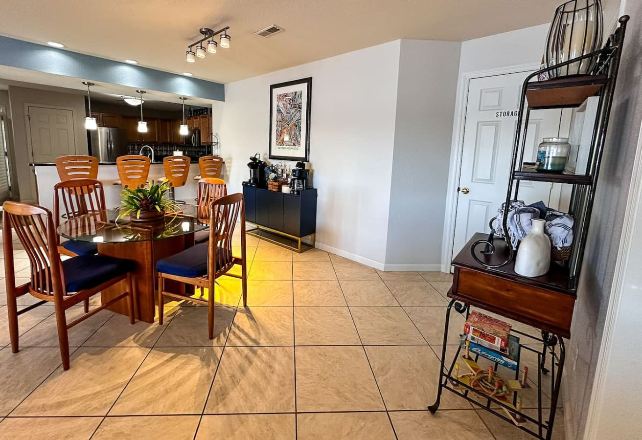 A modern, well-lit space featuring a coffee and beverage station stocked with essentials, along with barstool seating at the kitchen counter for casual meals or drinks.