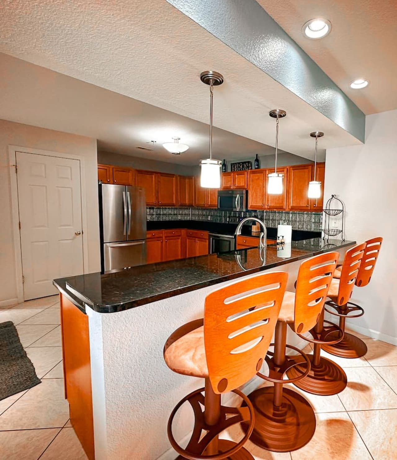 A granite countertop bar with four comfortable high-top stools, perfect for casual dining or sipping your morning coffee while enjoying the natural light.