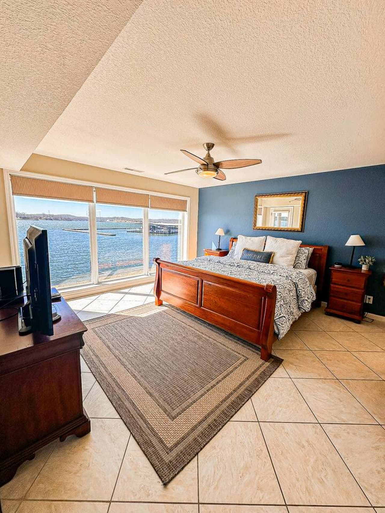 A stunning master suite with large windows that let in natural light and offer a breathtaking view of the lake.