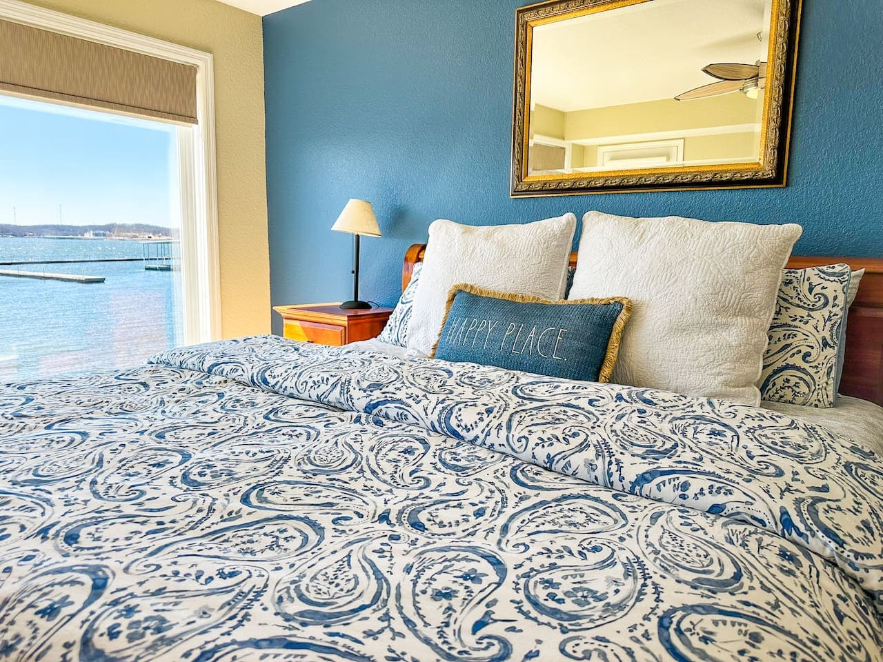 A bedroom designed for relaxation, featuring a plush bed, soft lighting, and a serene lakeside view.