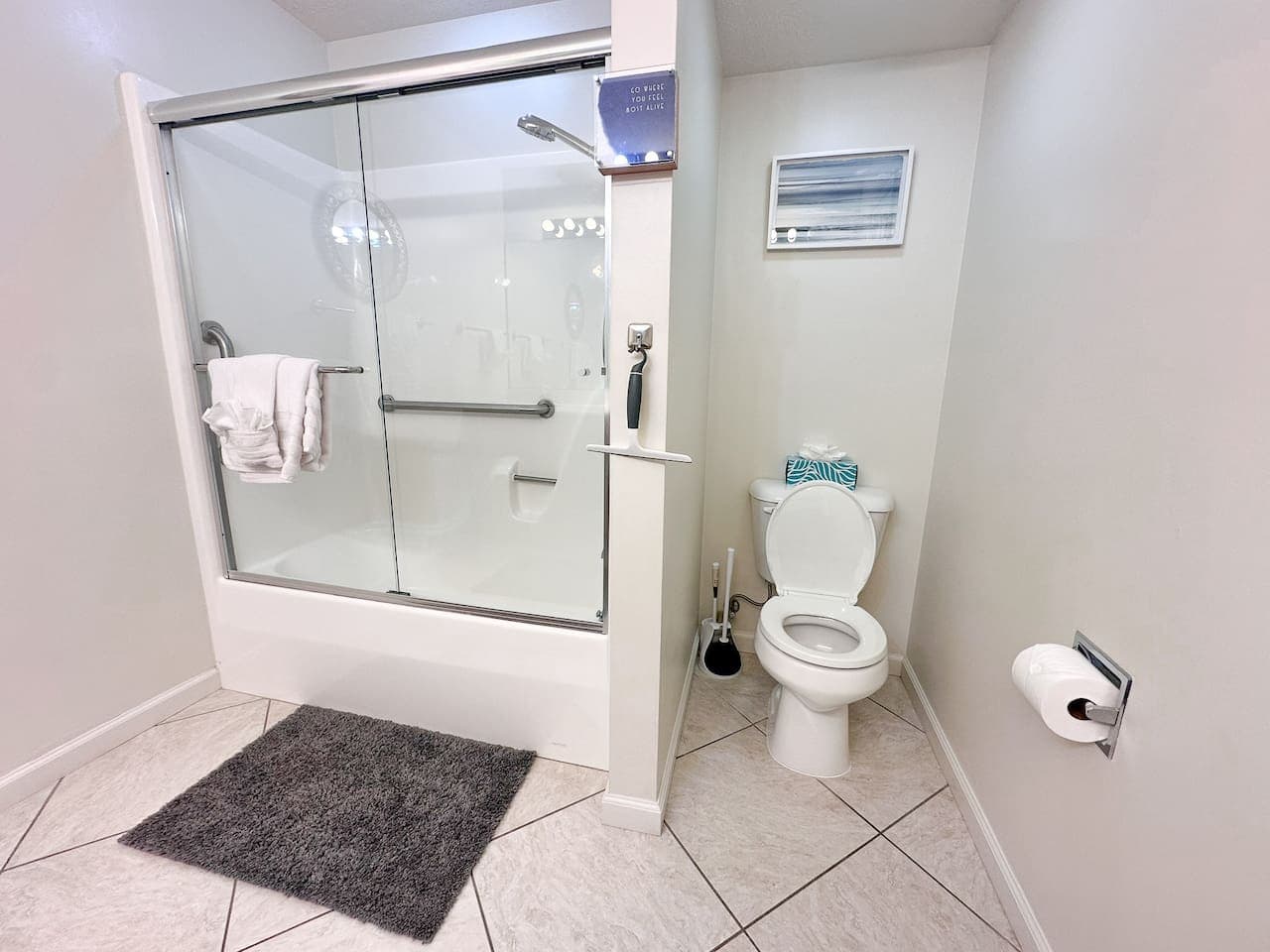 A  full bathroom with a walk-in shower and grab bars, offering both comfort and convenience for guests.