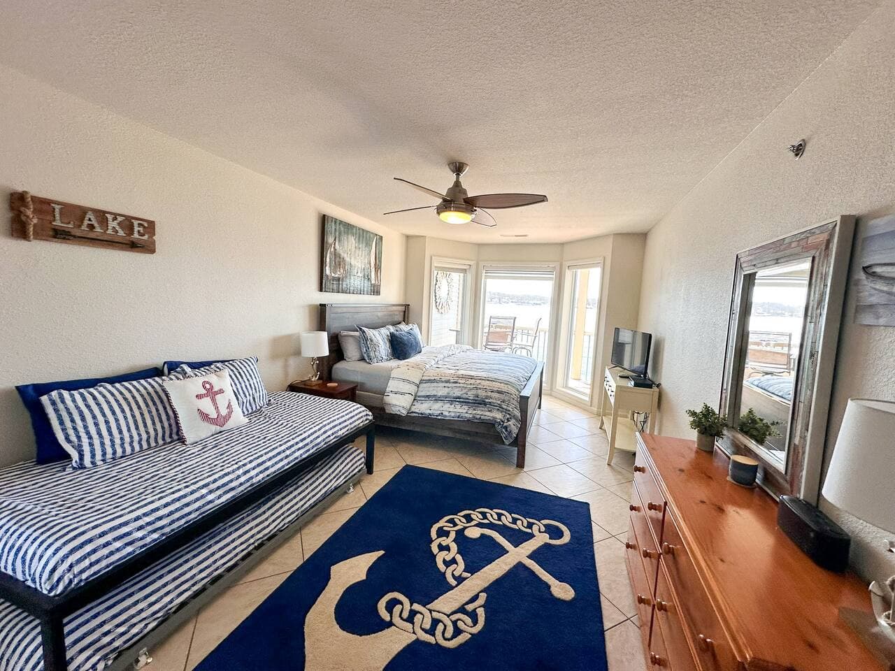 This charming bedroom offers flexible sleeping arrangements with a comfortable main bed and a convenient daybed, perfect for families or groups. Wake up to stunning water views from the large bay windows, adding a serene touch to your stay.