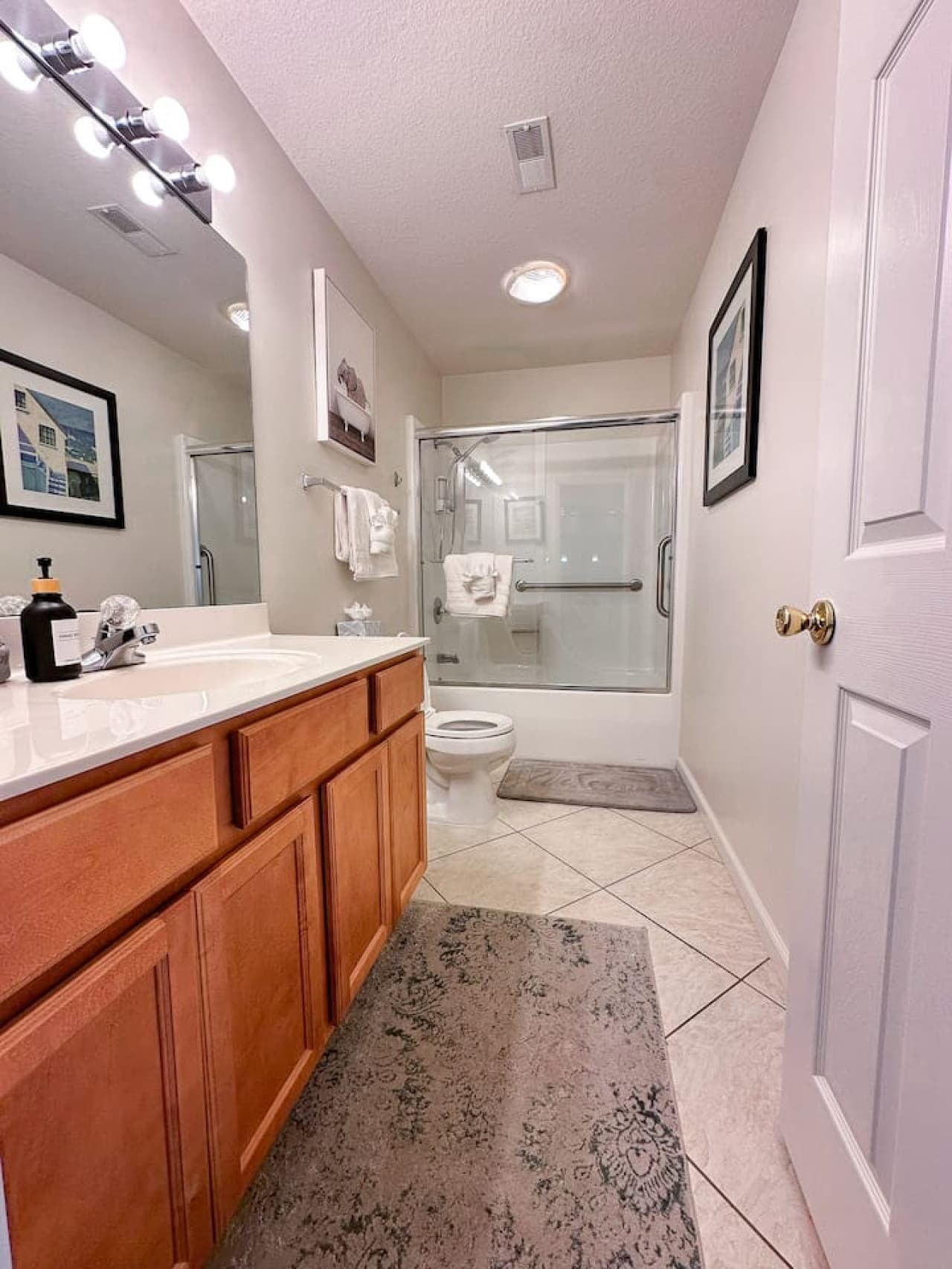 A bright and clean full bathroom featuring a glass-enclosed shower, plenty of counter space, and plush towels for a spa-like experience.