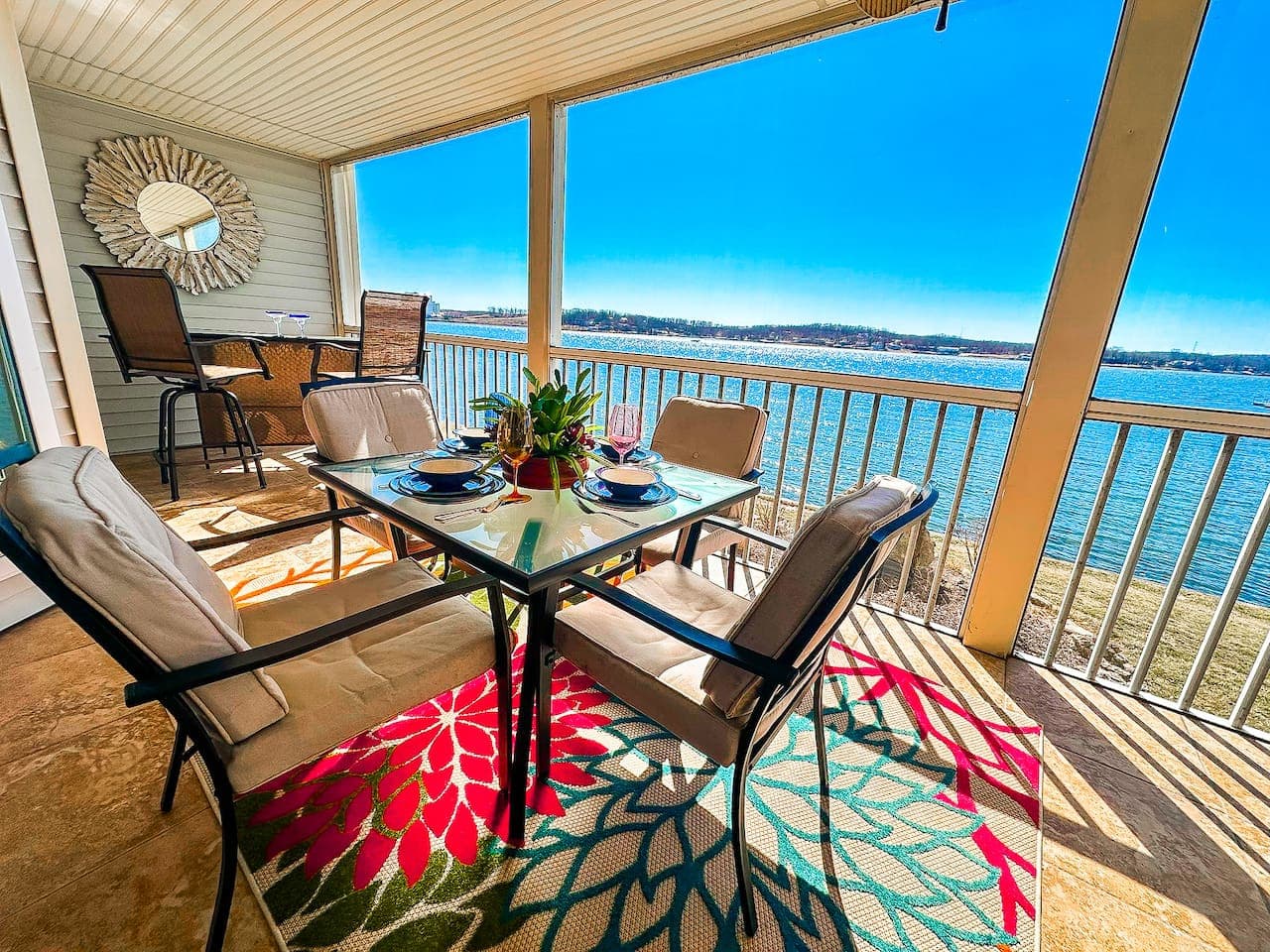A beautifully designed patio space with cozy seating and a picturesque lakefront setting.