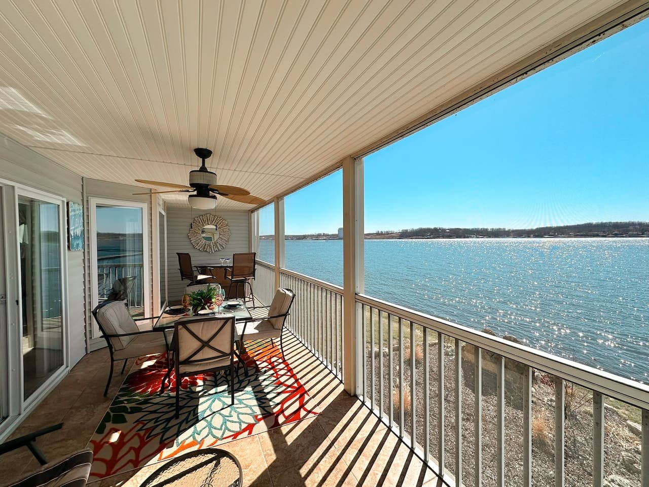 Enjoy meals with a breathtaking lake view on this stylish screened-in patio, complete with comfortable seating.