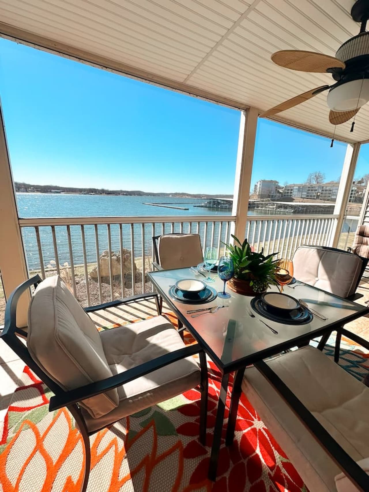 – A cozy outdoor dining setup with elegant tableware and stunning water views for a memorable meal.