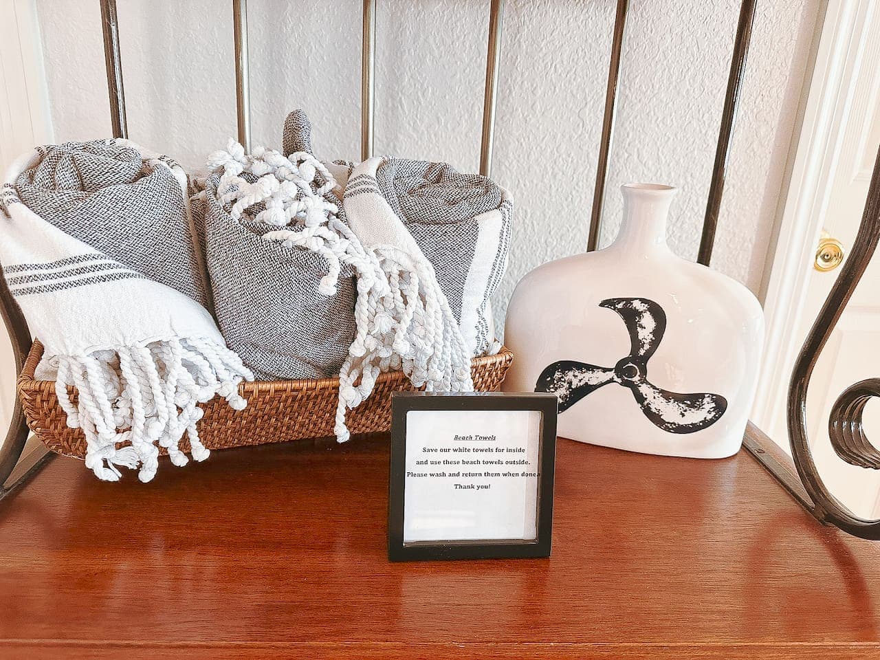 A beautifully arranged set of luxurious beach towels provided for guests, perfect for lake days. A small sign reminds guests to use these for outdoor adventures and return them after use.