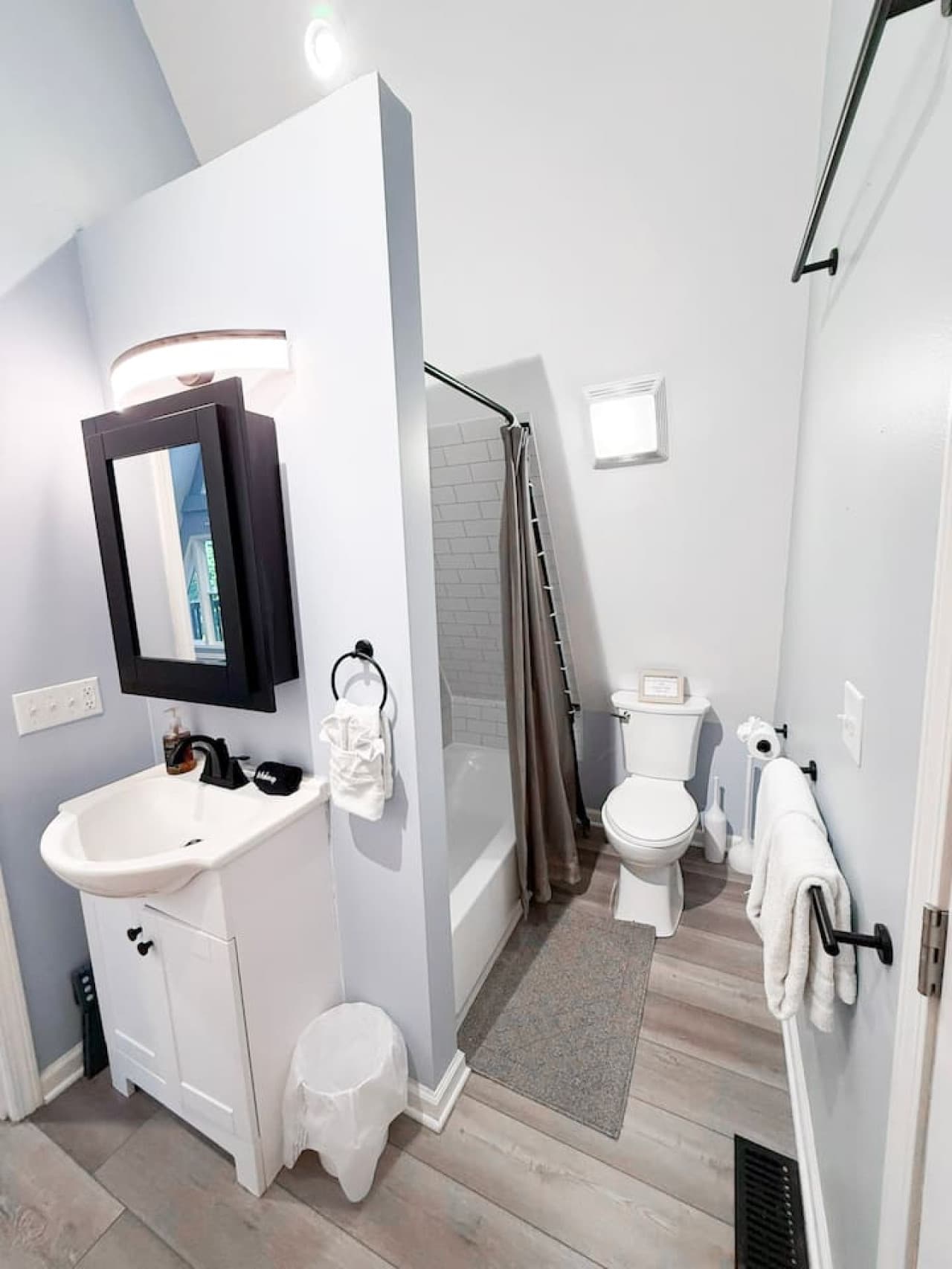 Main floor bathroom with a shower, bathtub, vanity and toilet area.