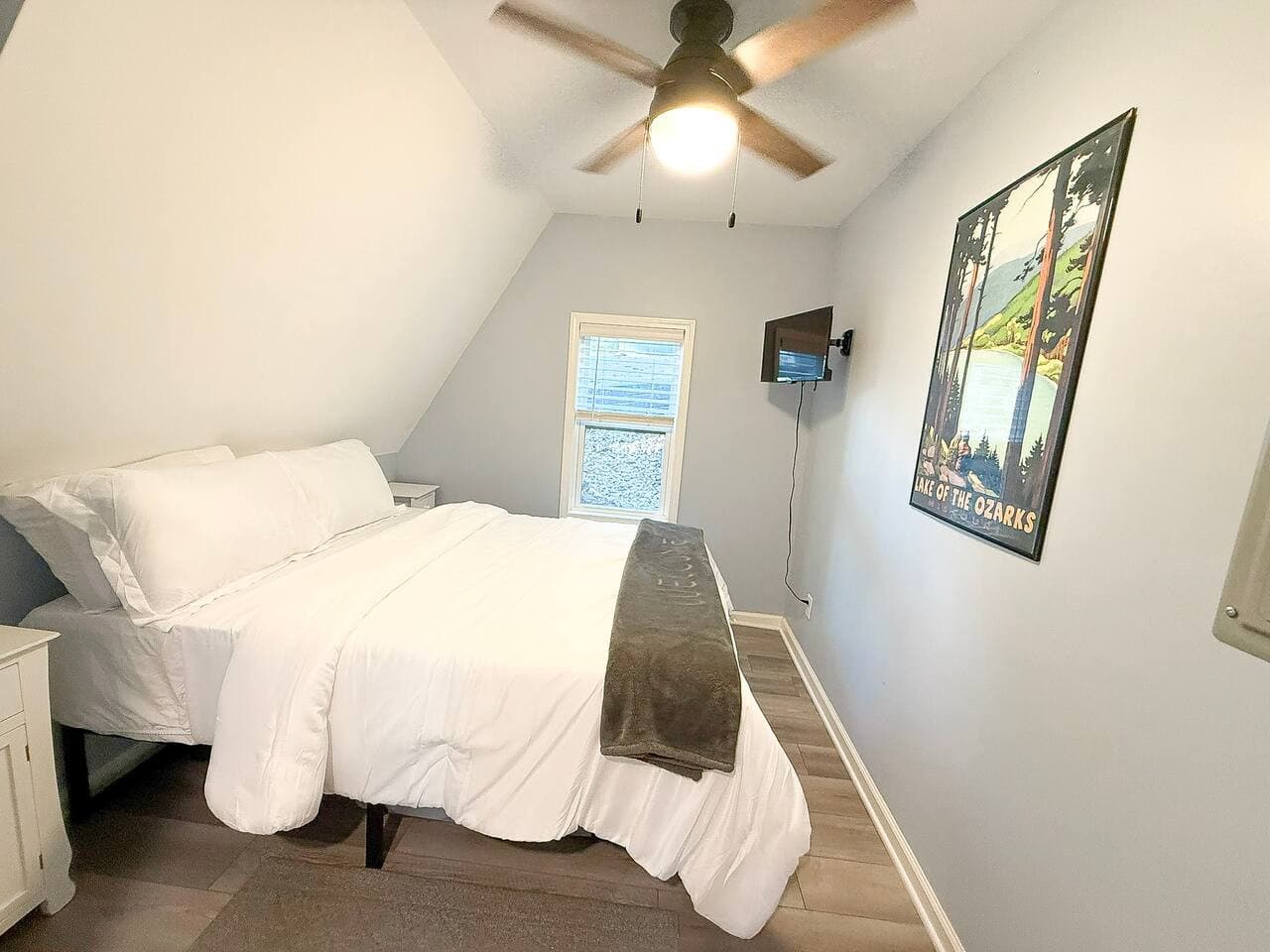Mainfloor bedroom with one queen bed and smart tv