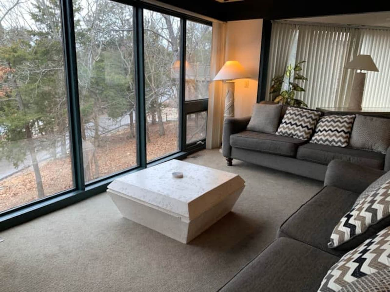 "Soak in the natural beauty from our bright living room. Large windows bring the outdoors in, creating a serene and inviting space."
