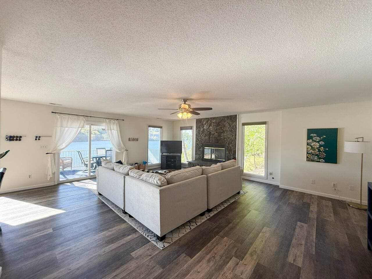Spacious living room with large sectional and lake views.