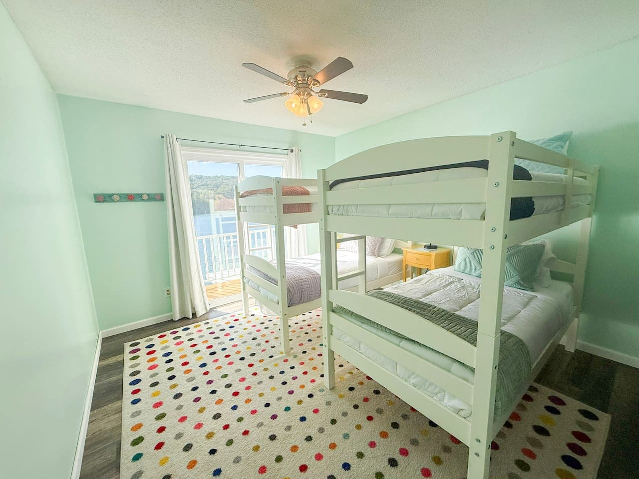 Bright lake-view room with two bunk beds and balcony access