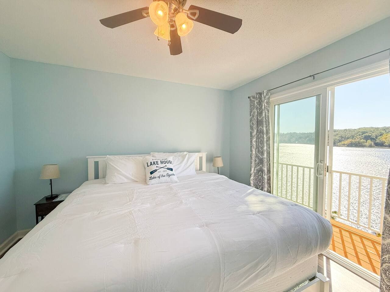 Bright lake-view king bedroom with balcony access.
