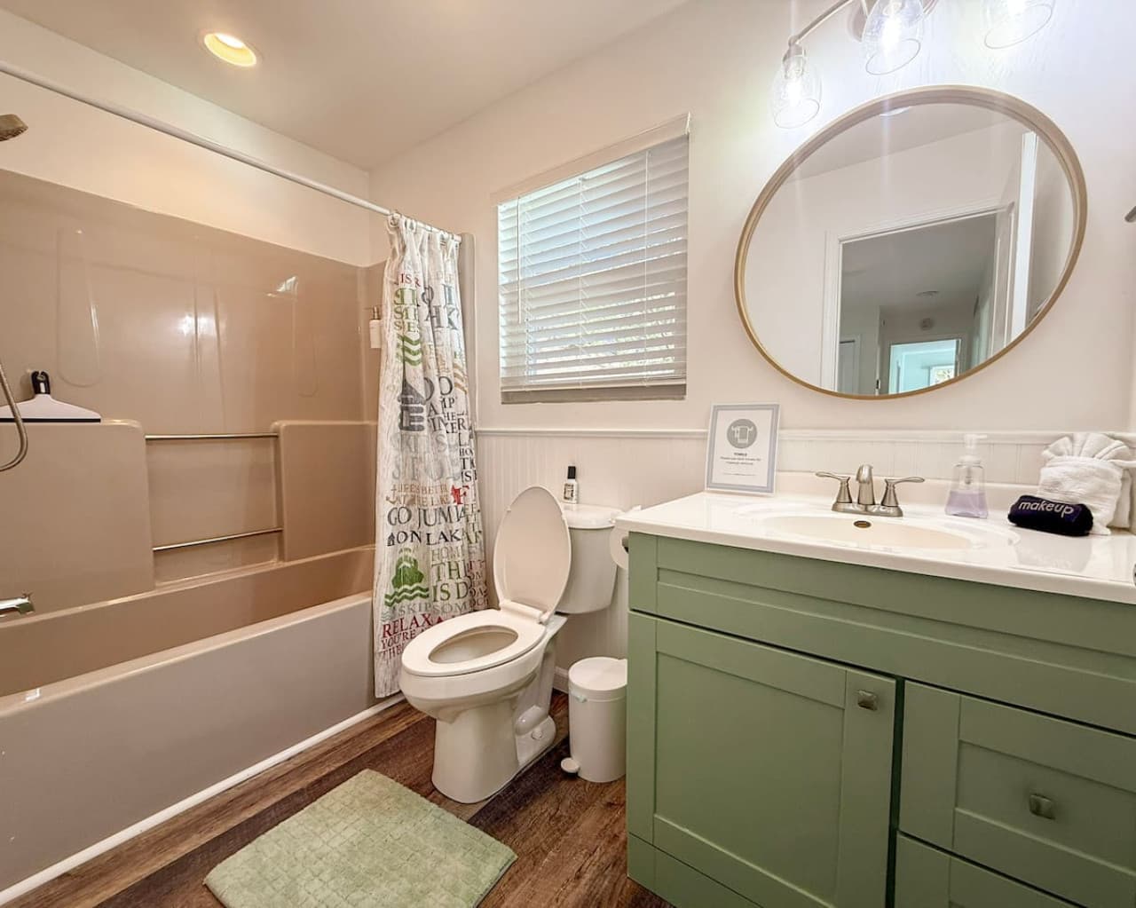 Fresh and modern bathroom with a spacious tub-shower combo and charming sage-green vanity
