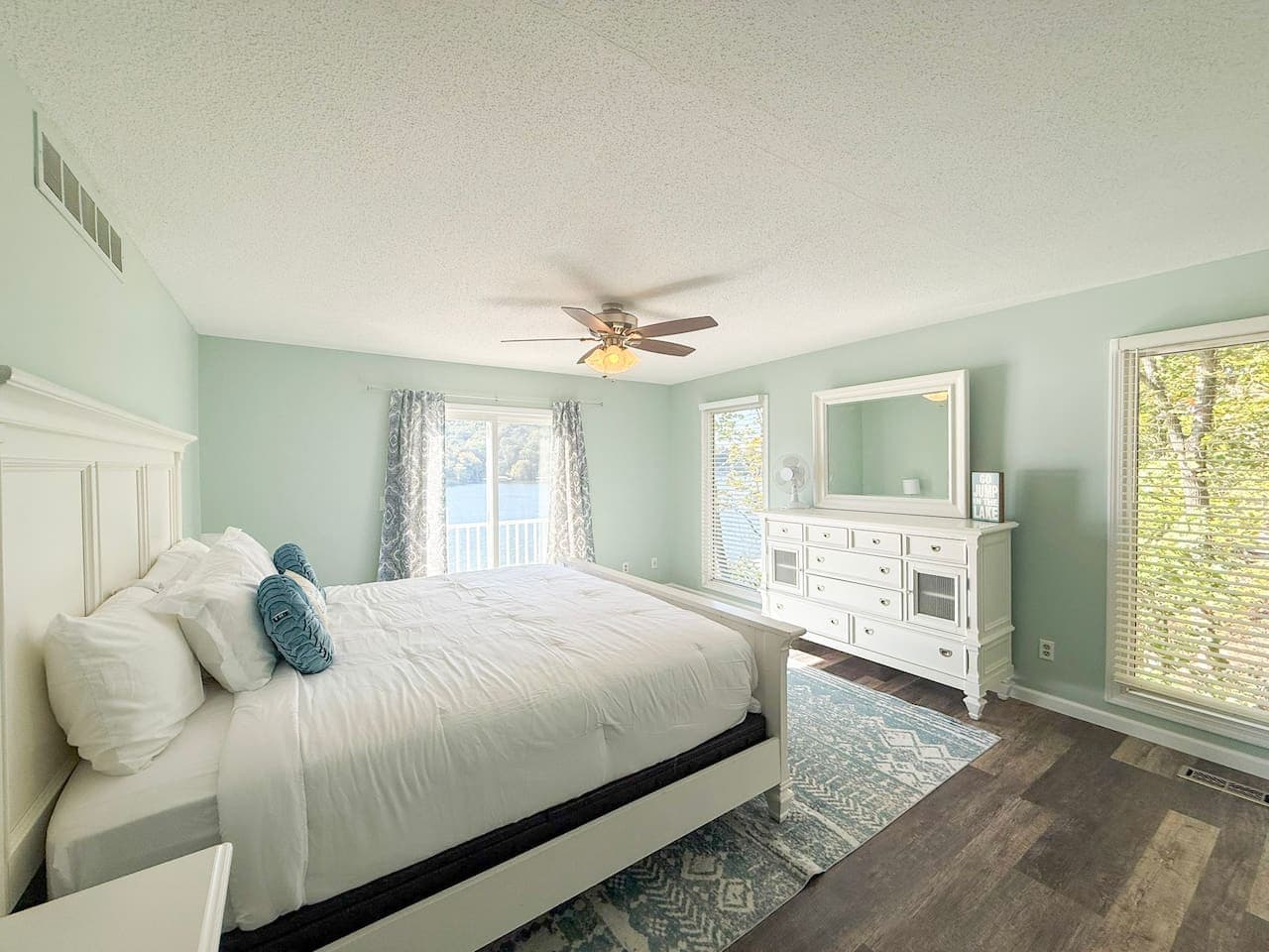 Bright bedroom with lake views and plush bedding.