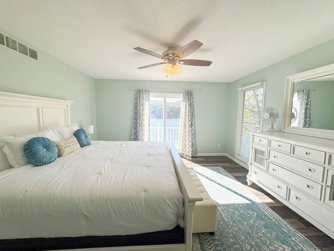 Spacious master bedroom with lake view and natural light.