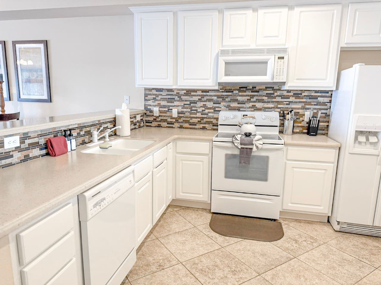 Cook and entertain with ease in this bright, fully equipped kitchen, featuring modern appliances and ample counter space.