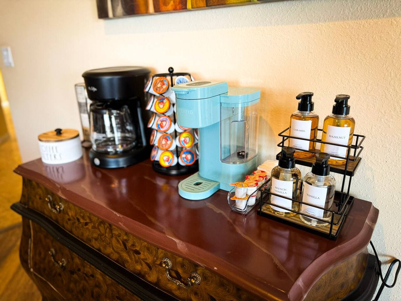Start your mornings at the fully stocked coffee and beverage station, featuring a drip coffee maker, pod options, and premium essentials.