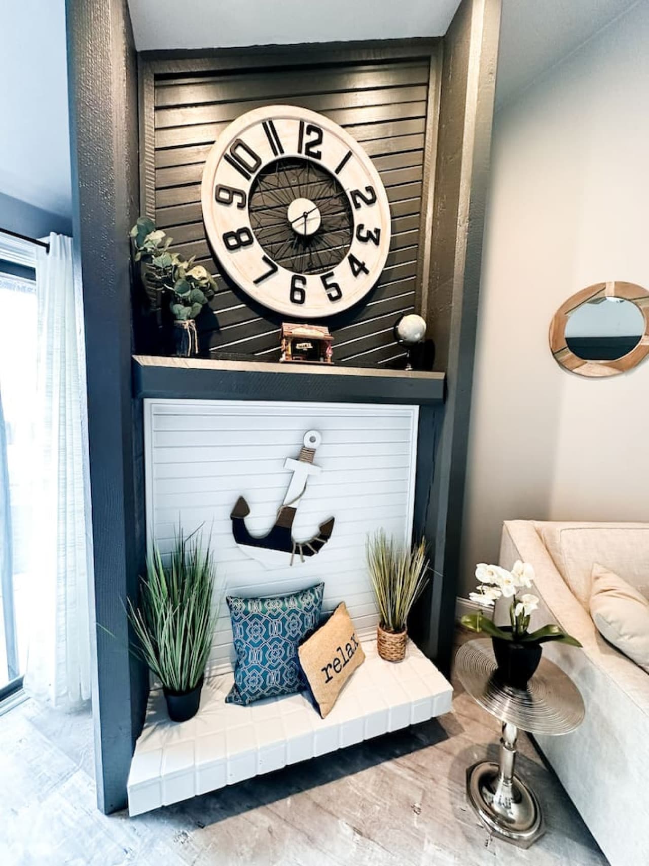 A beautifully decorated corner featuring a unique clock centerpiece and nautical accents. Relax and unwind in style.