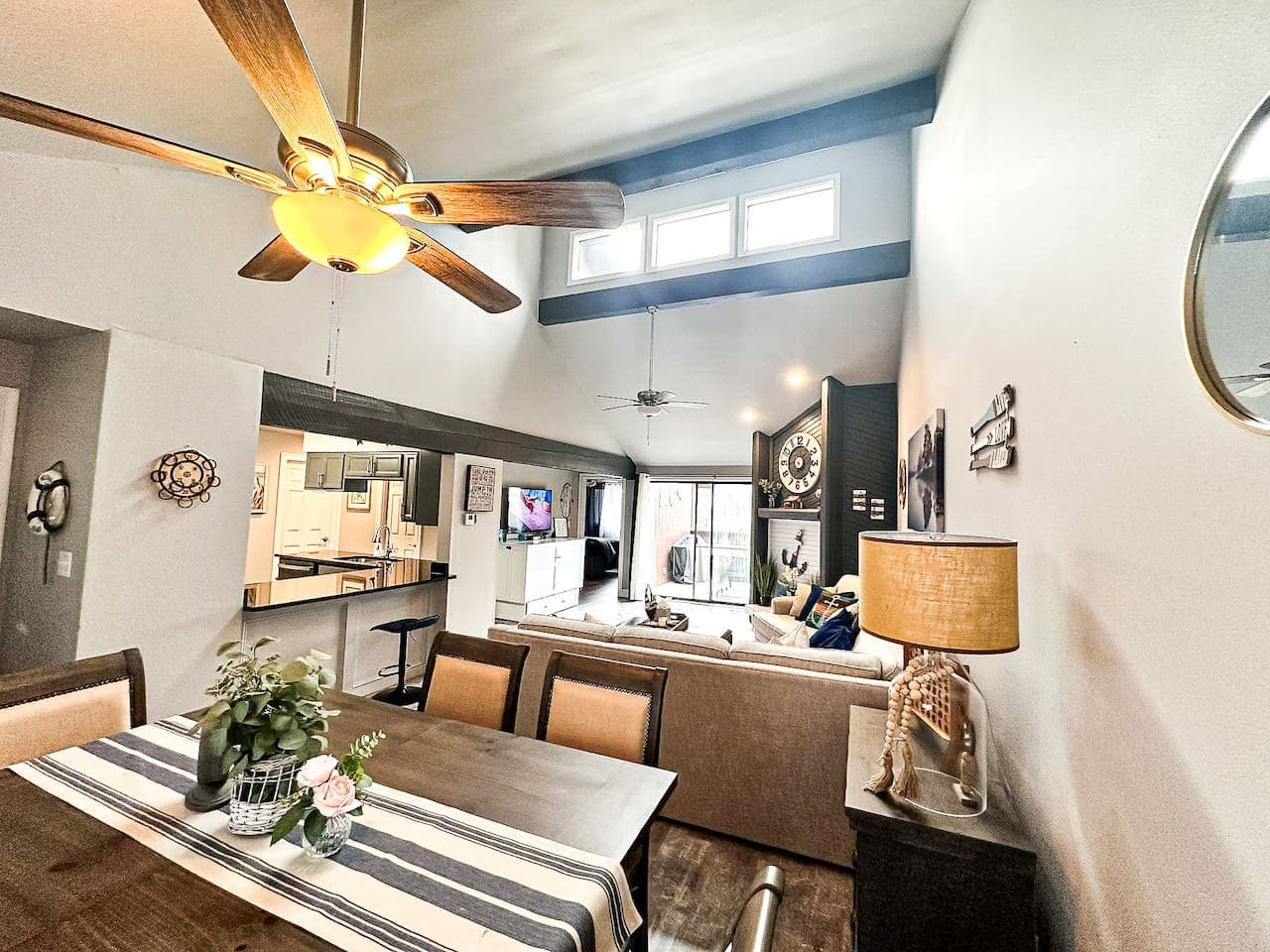 Open living room with access to private deck, large fireplace and the white console that the TV is sitting on is a full size murphy bed.