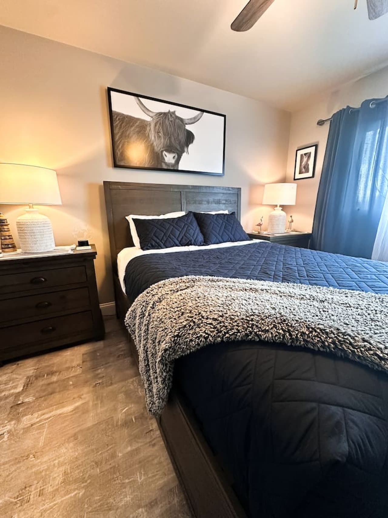 A bed adorned with a cozy navy quilt and fluffy accents, offering the perfect retreat.