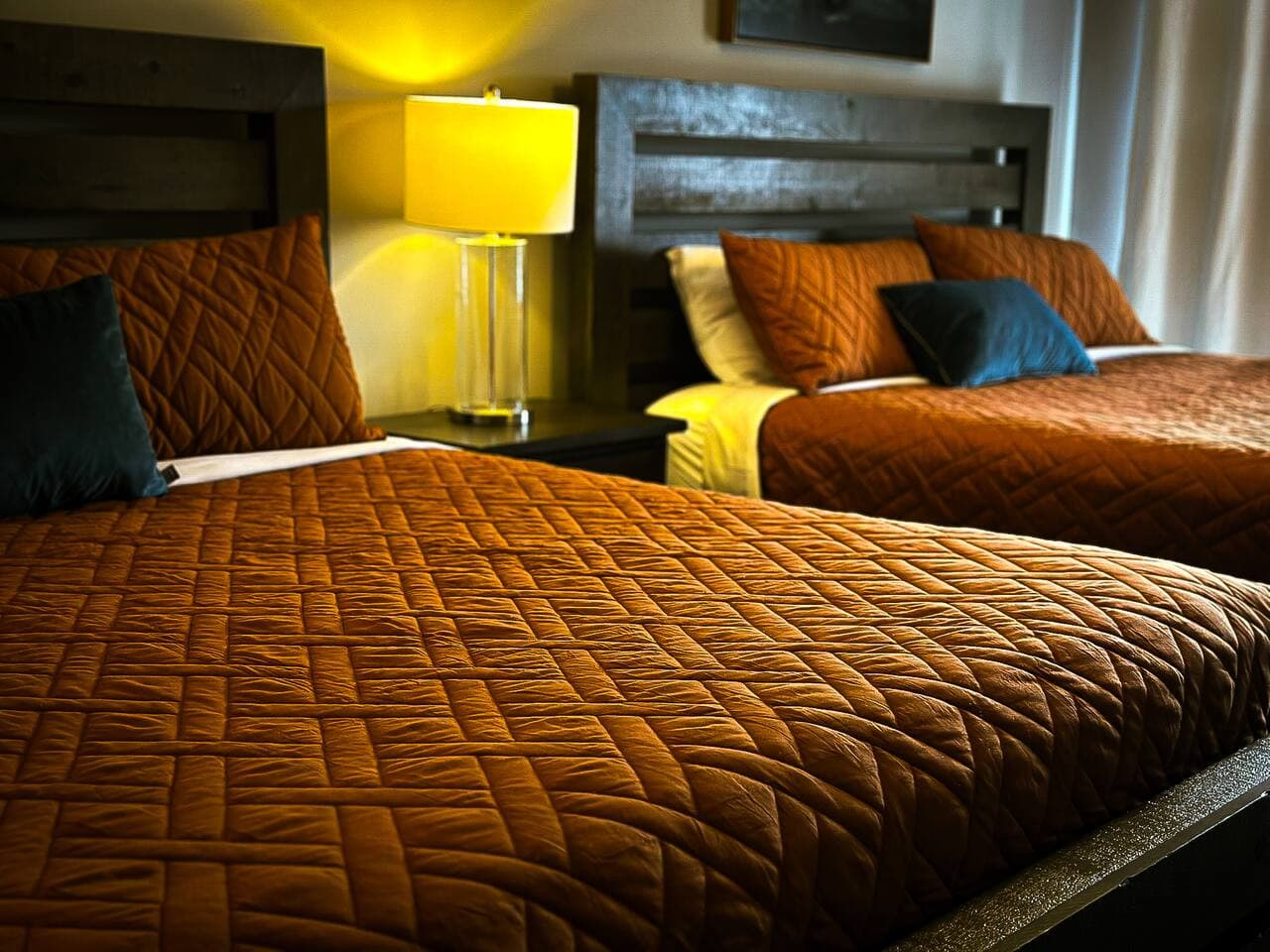Detailed shot of the plush bedding and stylish headboards in the bedroom, designed for a restful and stylish stay.