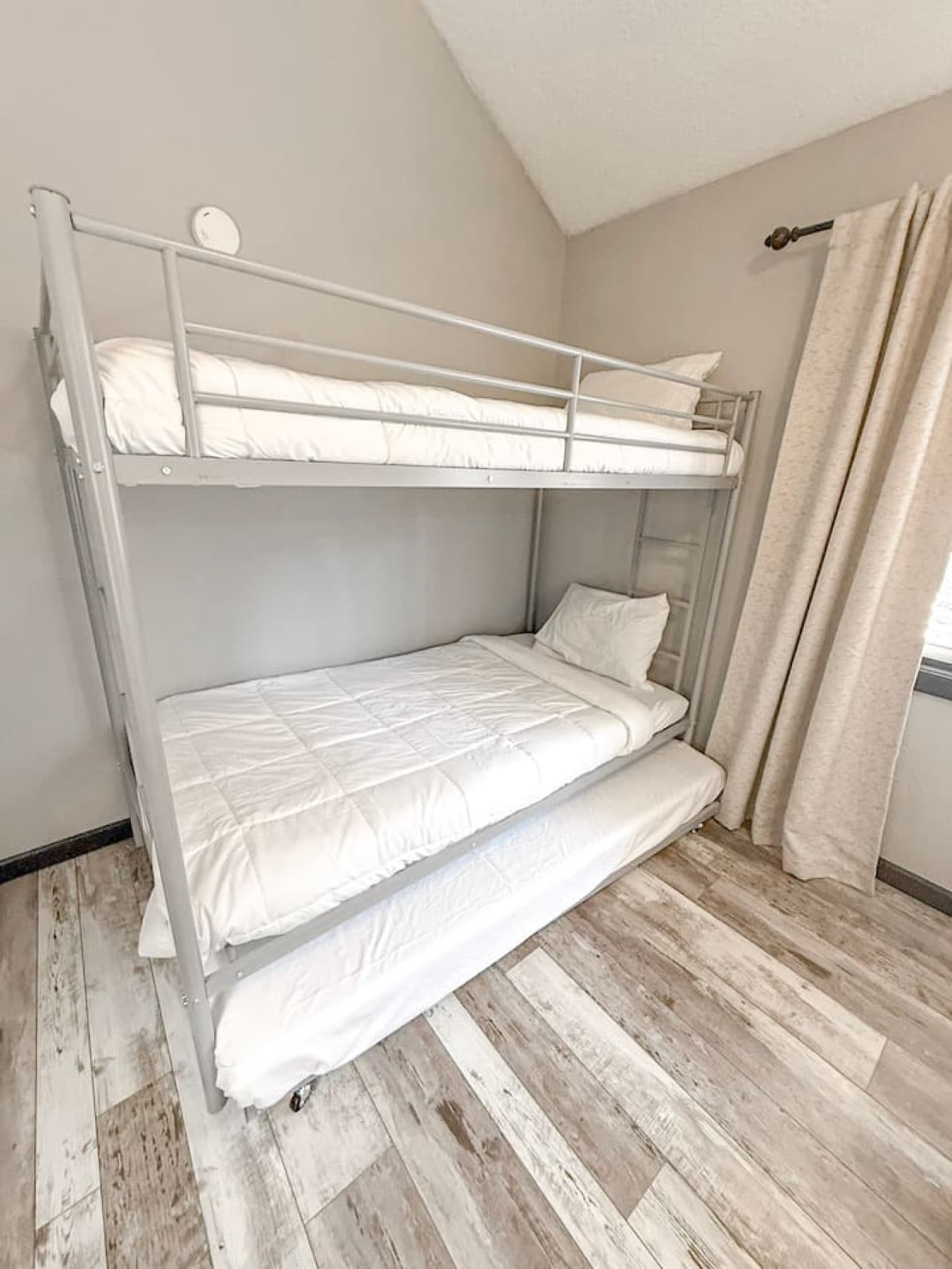 Bright and cozy bunk room perfect for kids or extra guests, featuring modern flooring and clean, simple décor.