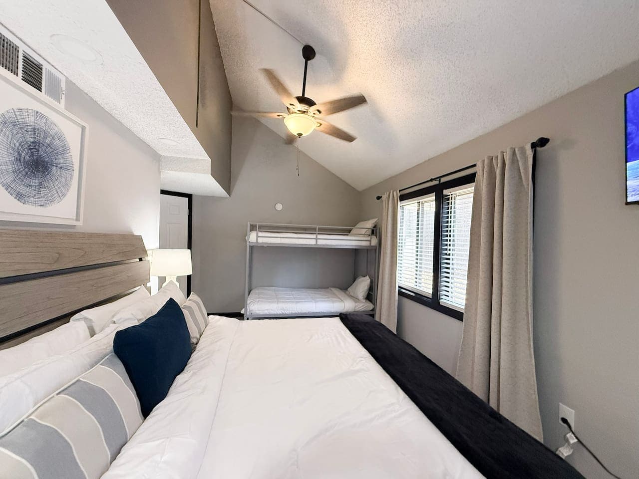 Spacious bedroom with a plush king bed and twin bunk beds — ideal for families or group stays.