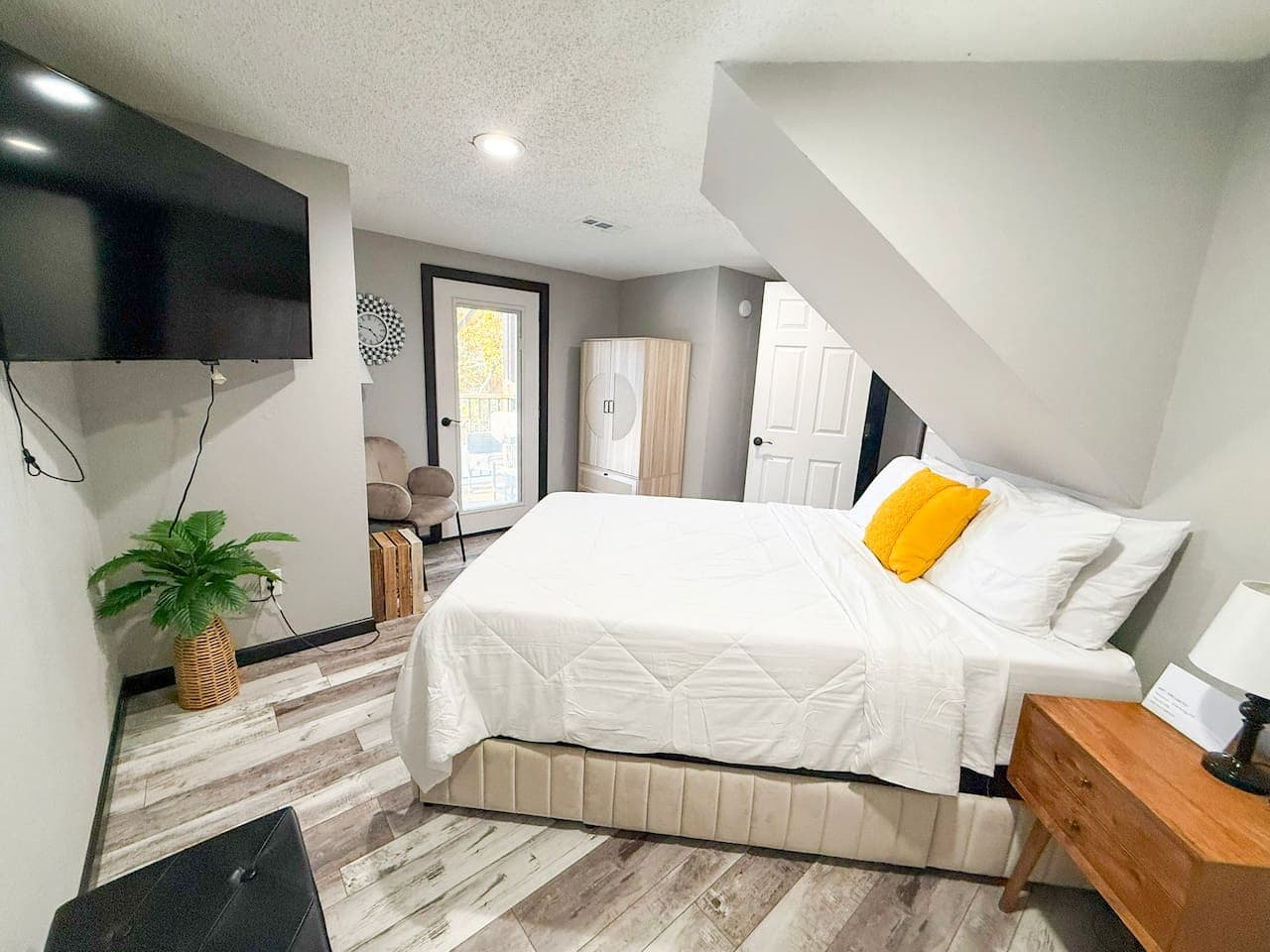 Stylish bedroom with TV, seating area, and outdoor access.