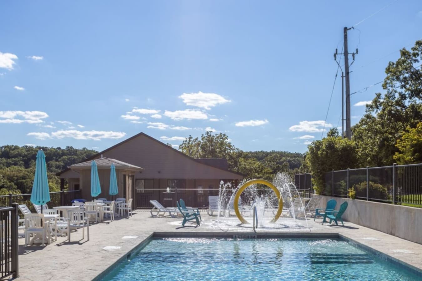 Large community pool with splash features and lounge seating.