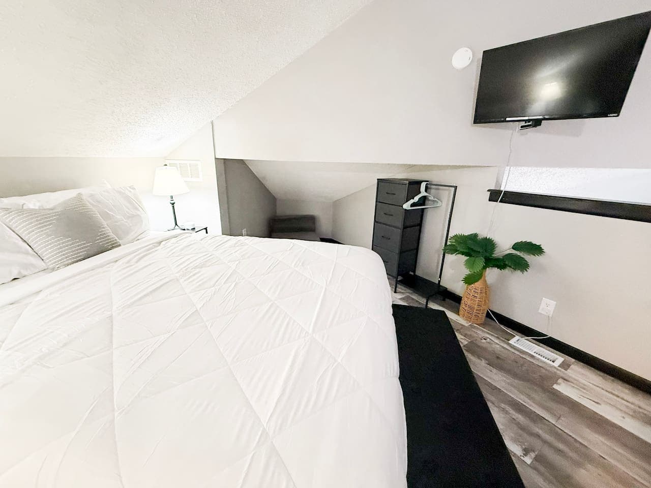 Cozy loft bedroom with a queen bed and TV.