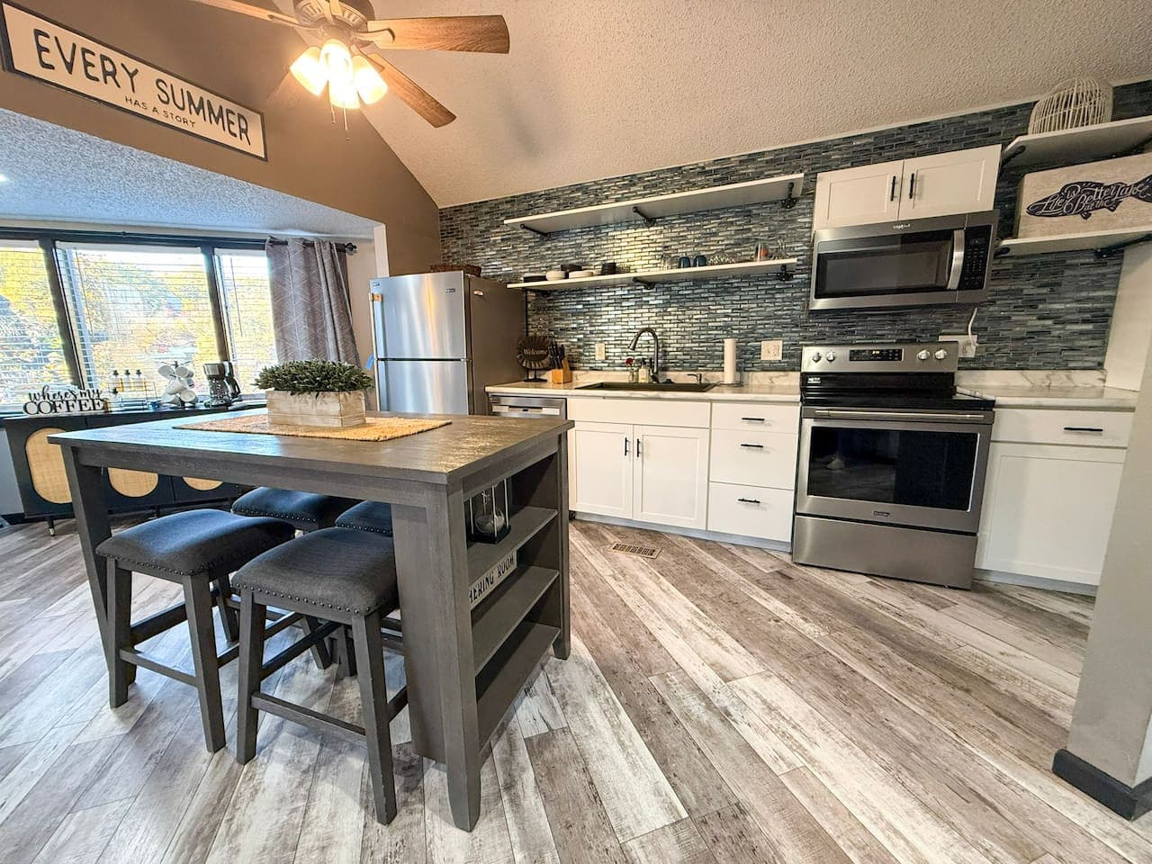 Modern kitchen with stainless steel appliances and breakfast island.