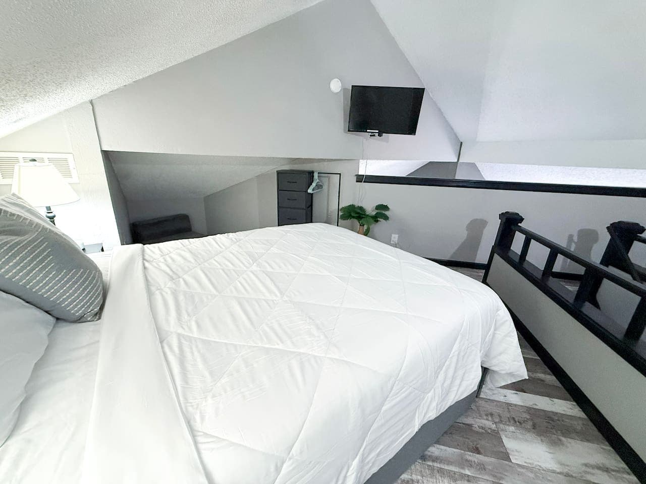 Peaceful loft bedroom with a cozy bed and TV.