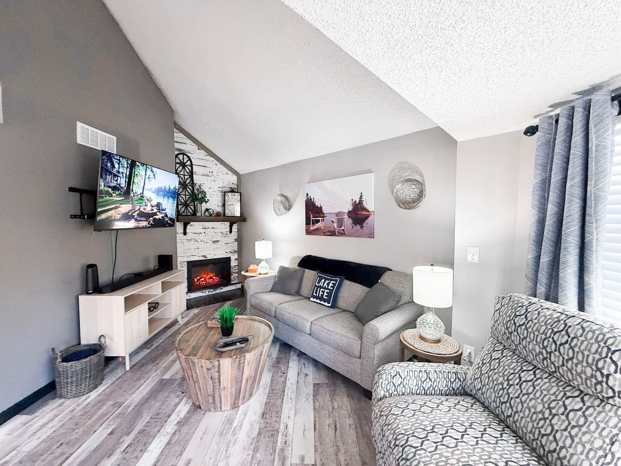 Cozy living room with TV, fireplace, and comfy seating.
