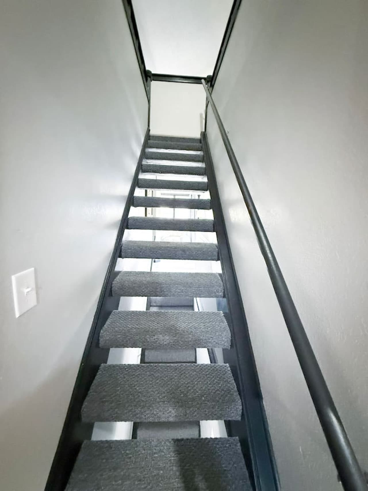 Carpeted stairs leading to the loft bedroom.