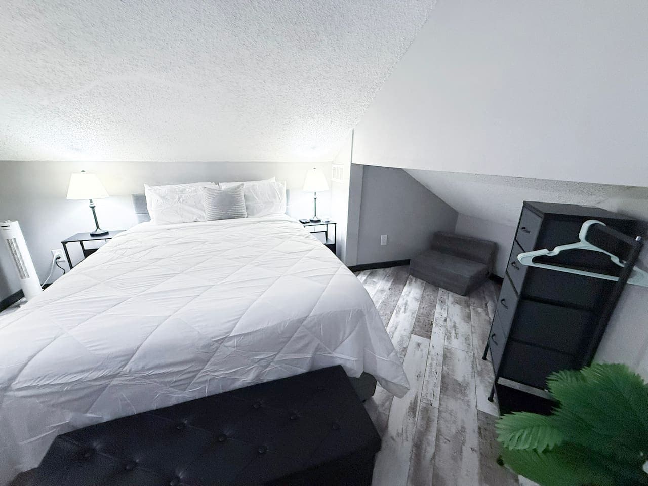 Comfortable loft bedroom with queen bed and soft lighting.