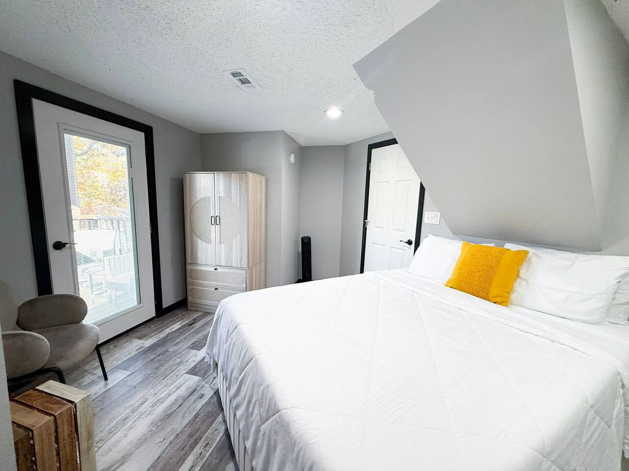 Bright bedroom with queen bed and outdoor access.