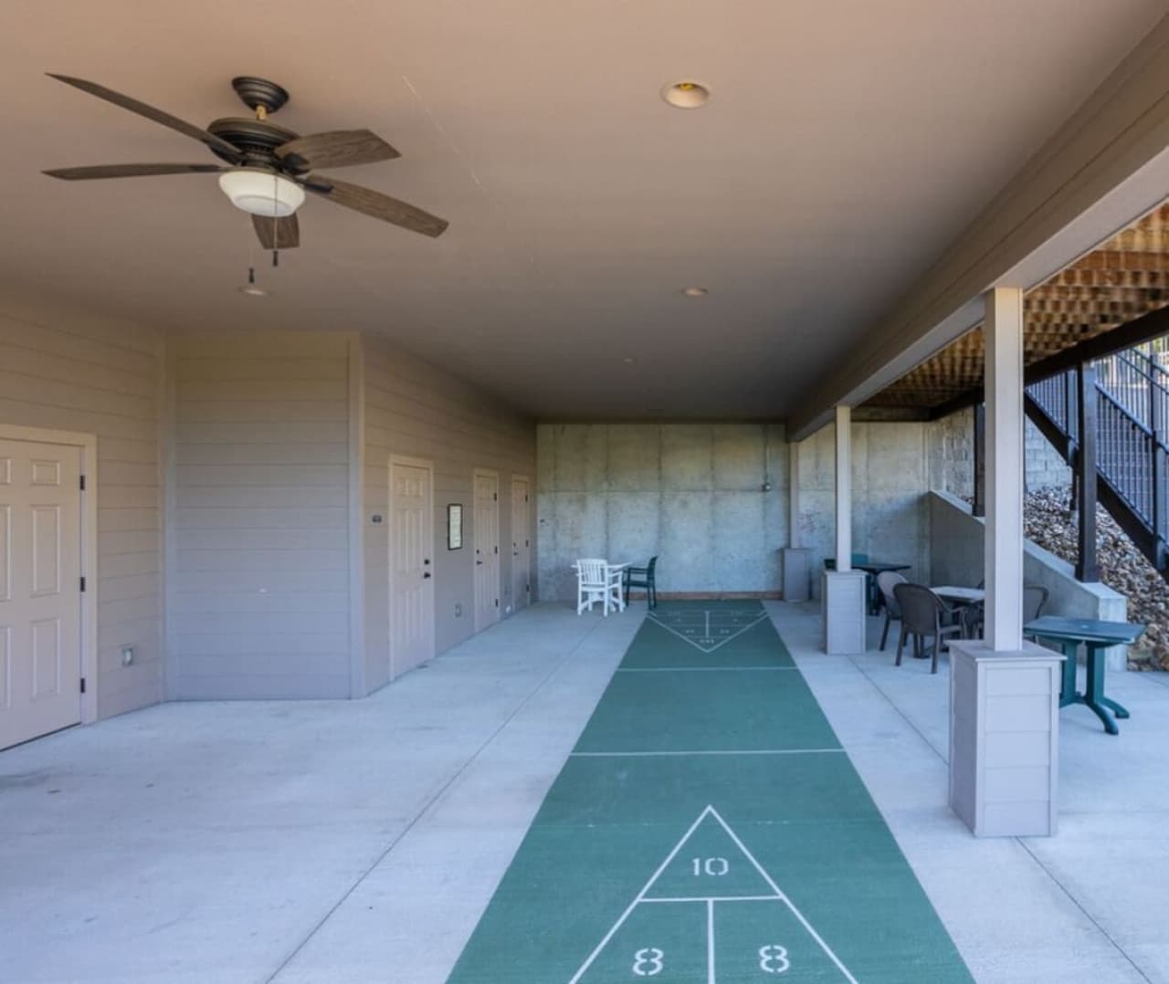 Covered shuffleboard court with seating nearby.