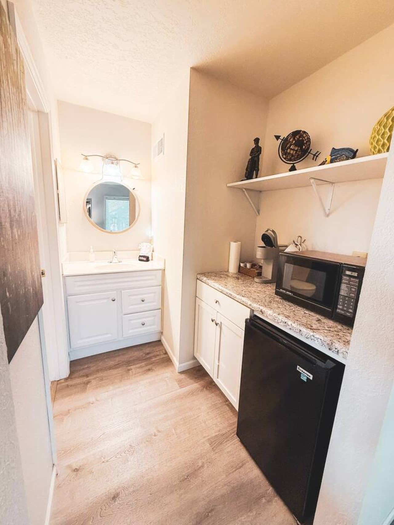 Enjoy the convenience of a modern kitchenette with a fridge, microwave, and ample counter space—perfect for quick meals and coffee breaks. Adjacent vanity area adds extra comfort and functionality for your stay.