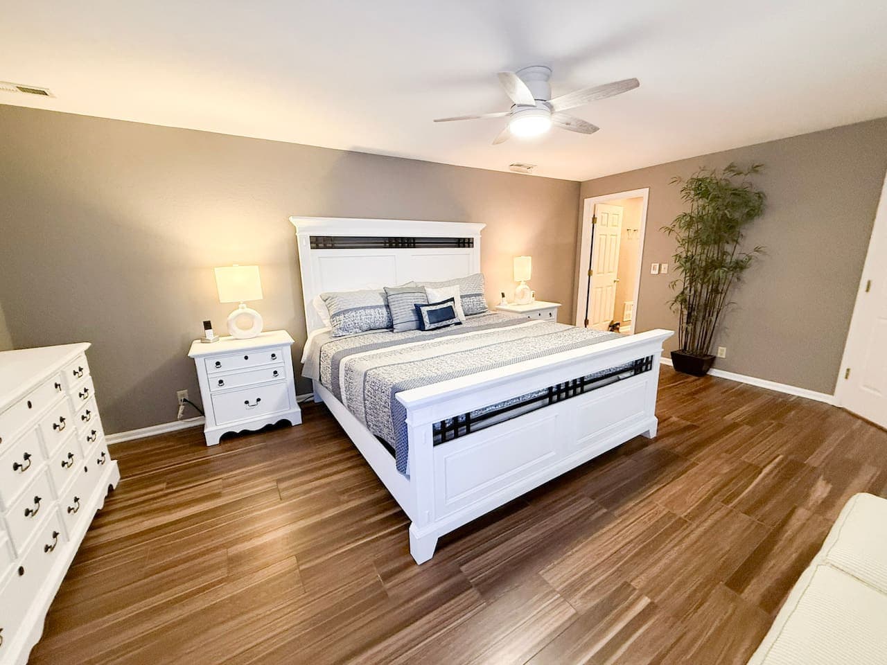 Spacious master suite with elegant king bed and warm flooring.